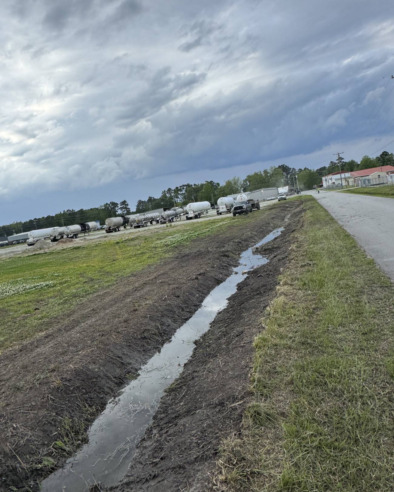 Newly cut roadside swale carrying water away from a property